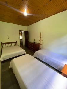 a bedroom with two beds in a room at Fazenda São Lourenço na Serra da Mantiqueira in Queimada