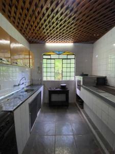 a large kitchen with a sink and a window at Fazenda São Lourenço na Serra da Mantiqueira in Queimada
