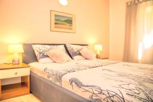 a small bedroom with a bed and a night stand at Apartments Petranić in Tisno