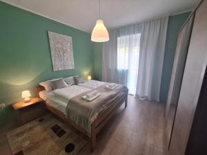 a bedroom with a bed and a large window at Apartman Lilium in Knin