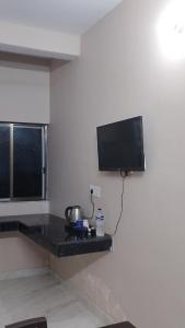 Zimmer mit einem TV an der Wand in der Unterkunft HOTEL RAMAYAN INN FREE PICKUP FROM AYODHYA DHAM RAILWAY STATION in Ayodhya