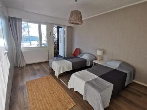 une chambre d'hôtel avec deux lits et une fenêtre dans l'établissement Vuori Camp by Saimaa, à Vuoriniemi