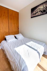 una camera da letto con un grande letto bianco con testiera in legno di Le Cosy Alfred Maury. Disneyland - Paris a Meaux