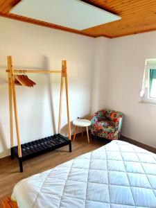 a bedroom with a bed and a chair in a room at APARTMA KAPELSKI FANT in Sveti Jurij ob Ščavnici