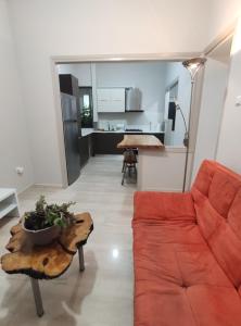 ein Wohnzimmer mit einem roten Sofa und einem Tisch in der Unterkunft anamnesis Agrinio in Agrinio