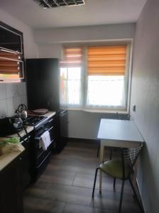Mieszkanie w Tucholi في توكولا: مطبخ مع موقد وطاولة مع كرسي