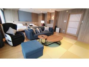 sala de estar con sofá, mesa y cama en Rishiri Fuji Kanko Hotel - Vacation STAY 63409v en Oshidomari