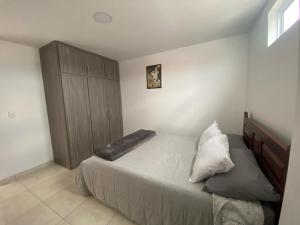 1 dormitorio con 1 cama grande y armario de madera en Apartamento Descanso Central, en Filandia
