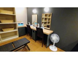 ein Büro mit einem Schreibtisch mit Stühlen und einem Ventilator in der Unterkunft Rishiri Fuji Kanko Hotel - Vacation STAY 63414v in Oshidomari