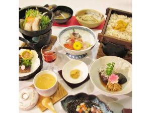einen Tisch mit Teller mit Lebensmitteln und Schüsseln mit Lebensmitteln in der Unterkunft Rishiri Fuji Kanko Hotel - Vacation STAY 63409v in Oshidomari