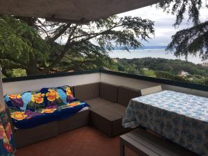 a balcony with a table and a couch with a view at Locazione Turistica Via Del Pucino in Grljan