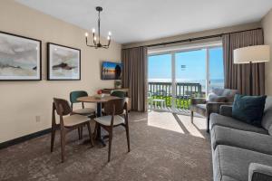 een woonkamer met een bank en een tafel met stoelen bij Schooner's Cove Inn in Cannon Beach