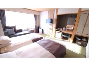 Cette chambre comprend deux lits et une télévision. dans l'établissement Rishiri Fuji Kanko Hotel - Vacation STAY 63414v, à Oshidomari