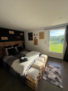 a bedroom with a large bed and a large window at Maison Goxoki 