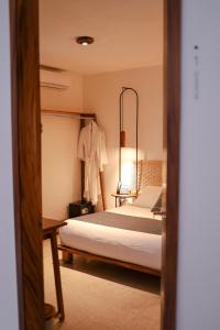 a bedroom with a bed and a robe on a rack at Hotel Boutique Casa de Arte Oaxaca, Art Gallery & Pool in Oaxaca City