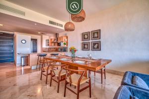 a kitchen and dining room with a wooden table and chairs at Amazing 2BR Condo with Pool and Access to VIDANTA in Nuevo Vallarta 