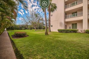 a building with a palm tree and a sign in a yard at Amazing 2BR Condo with Pool and Access to VIDANTA in Nuevo Vallarta 
