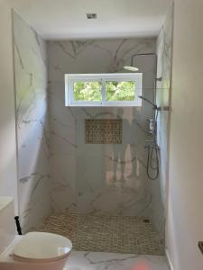 bagno con doccia in marmo e finestra di Family House in La Romana a La Romana