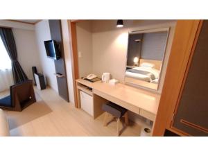 Habitación de hotel con escritorio y espejo en Rishiri Fuji Kanko Hotel - Vacation STAY 63411v, en Oshidomari