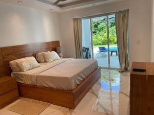 Schlafzimmer mit einem Bett und einer Glasschiebetür in der Unterkunft Family House in La Romana in La Romana