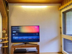 a flat screen tv sitting on a wooden stand next to a wall at Sunny Stay with Mountain in Siegsdorf