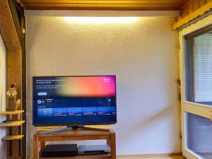 a flat screen tv sitting on a wooden stand next to a wall at Holiday apartment Siegsdorf in Bavaria in Siegsdorf