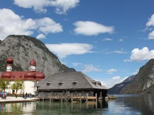 a building on the water next to a mountain at Holiday apartment Siegsdorf in Bavaria in Siegsdorf