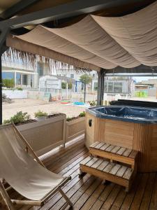 - Terraza con silla y bañera de hidromasaje en Boutique Citadel, en Eforie Nord
