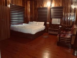 KADAMBINI JUNGLE RESORT في لاتاغري: غرفة نوم بسرير كبير مع شراشف بيضاء