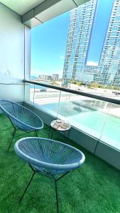 due sedie e un tavolo davanti ad una grande finestra di Wonderful two bed room with full marina view a Dubai