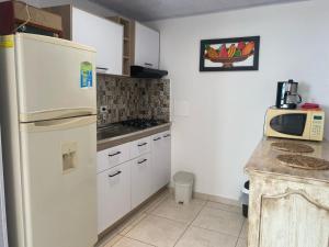 cocina con nevera blanca y microondas en Apartamento Descanso Central, en Filandia