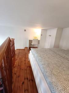 Un dormitorio con una cama y suelo de madera. en Old Town Mezzanine Apartment, en Gdansk