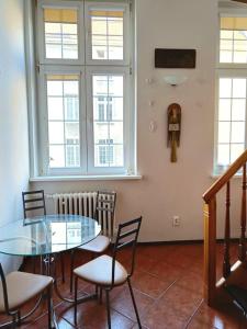 Un comedor con una mesa de cristal y sillas. en Old Town Mezzanine Apartment, en Gdansk
