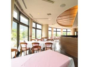ein Esszimmer mit Tischen, Stühlen und Fenstern in der Unterkunft Akinomiya Sanso - Vacation STAY 46121v in Yuzawa