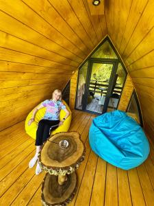 a woman sitting in a room in a tree house at U Yaroslava Hotel in Yaremche