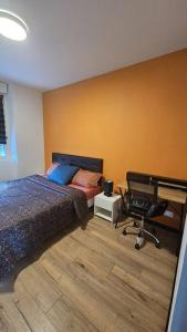 Schlafzimmer mit einem Bett, einem Schreibtisch und einem Stuhl in der Unterkunft Maisonnette Proche plage in Brest