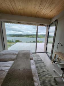 um quarto com uma grande janela com vista para um lago em Lake View Apartments Beinwil am See (30 km to Lucerne) em Beinwil
