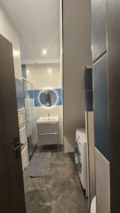 ein kleines Bad mit einem Waschbecken und einem Spiegel in der Unterkunft Maisonnette Proche plage in Brest