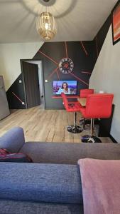ein Wohnzimmer mit einem Sofa, Stühlen und einem TV in der Unterkunft Maisonnette Proche plage in Brest