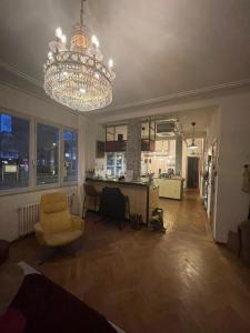 a living room with a chandelier and a chair at stijlvol appartement centrum oostende in Ostend