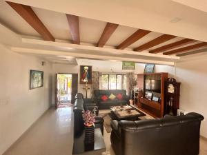 ein Wohnzimmer mit Ledermöbeln und Kassettendecke in der Unterkunft Captains Cabin backwater resort in Alappuzha
