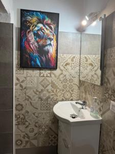 a bathroom with a painting of a lion on the wall at Civico 10 II in Sassari