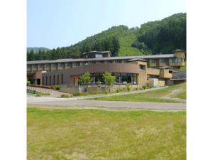 ein Gebäude mit einer Straße vor einem Berg in der Unterkunft Akinomiya Sanso - Vacation STAY 46104v in Yuzawa