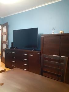 ein Wohnzimmer mit einem TV und einer Kommode mit einem Tisch in der Unterkunft GREEN AP Nalkowskich in Lublin