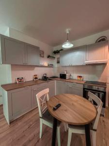 a kitchen with a wooden table and a table and chairs at 2 Șic rooms Park Copou AB Homes in Iaşi