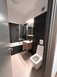 a bathroom with a white toilet and a sink at 2 Șic rooms Park Copou AB Homes in Iaşi