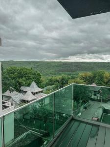 a glass balcony with a view of a garden at 2 Șic rooms Park Copou AB Homes in Iaşi