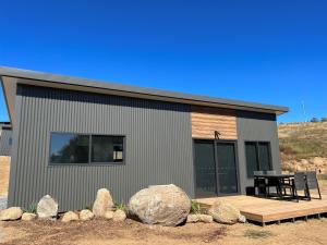 a small house with a deck and a table at Hygge Eco Cabins in Jindabyne