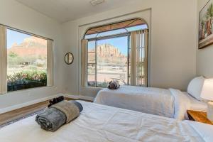 two beds in a room with two large windows at Sedona Chapel Area Charm Red Rock Views, Outdoor Dining, Near Hiking, Pets OK in Sedona
