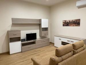 ein Wohnzimmer mit einem Sofa und einem Flachbild-TV in der Unterkunft Nel cuore della Tuscia, 4 posti letto. in Tuscania